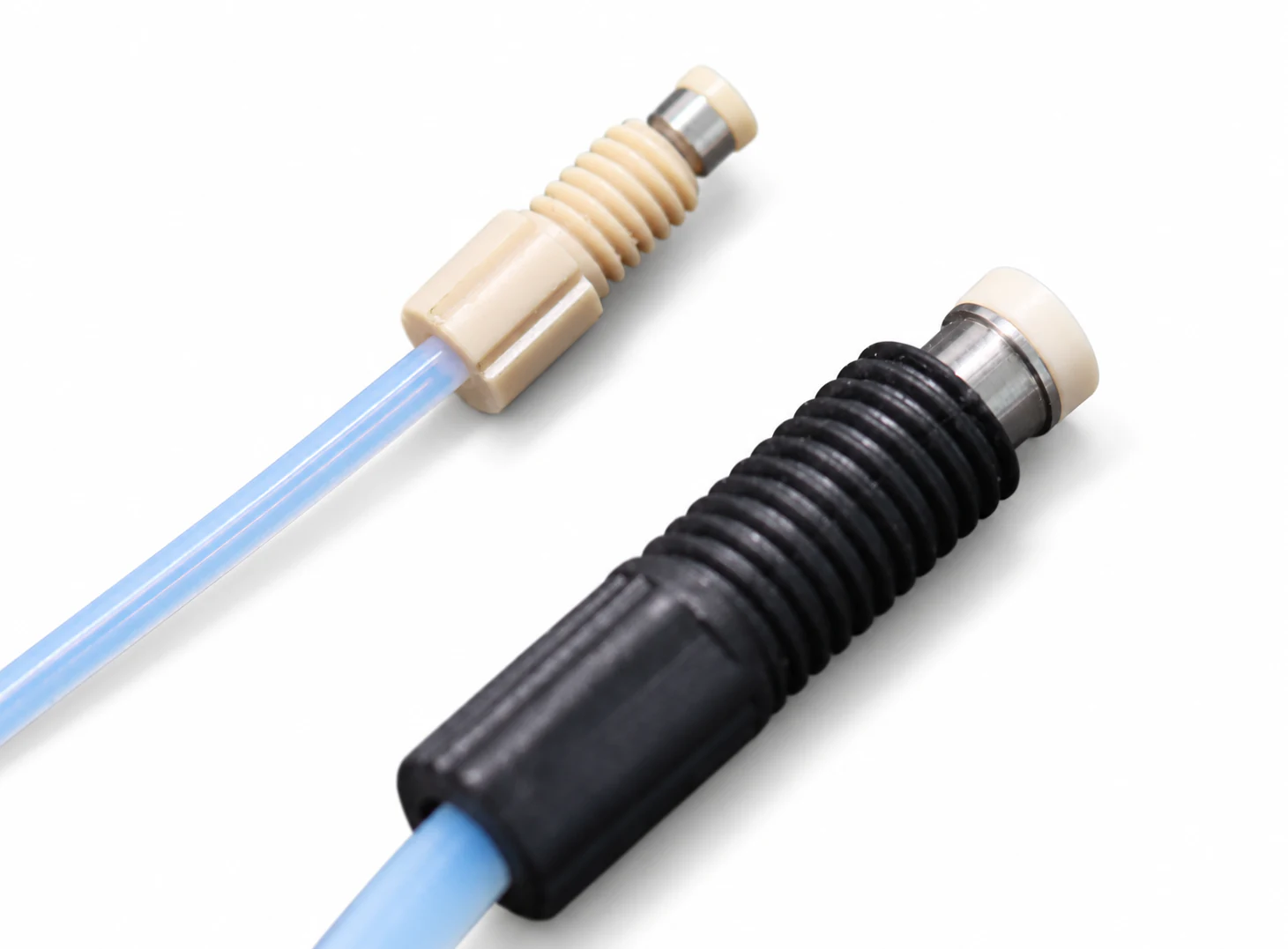 Retaining-ring tubing assemblies on white, with natural PEEK and black fittings, metal sleeves, sealing washers and tubing